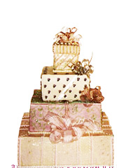 Photograph of four tier cake shaped like packages.