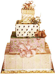 large package shaped cake frosted in pastel colors trimmed in edible gold