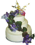three tiered stacked cake with  garland of irises, orchids, and handmade paper dragon flies